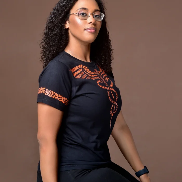 Modelo usando camiseta preta da coleção DIVINO com símbolo médico laranja