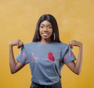 Modelo usando camiseta cinza Feel the Beat com coração anatômico e linha de ECG