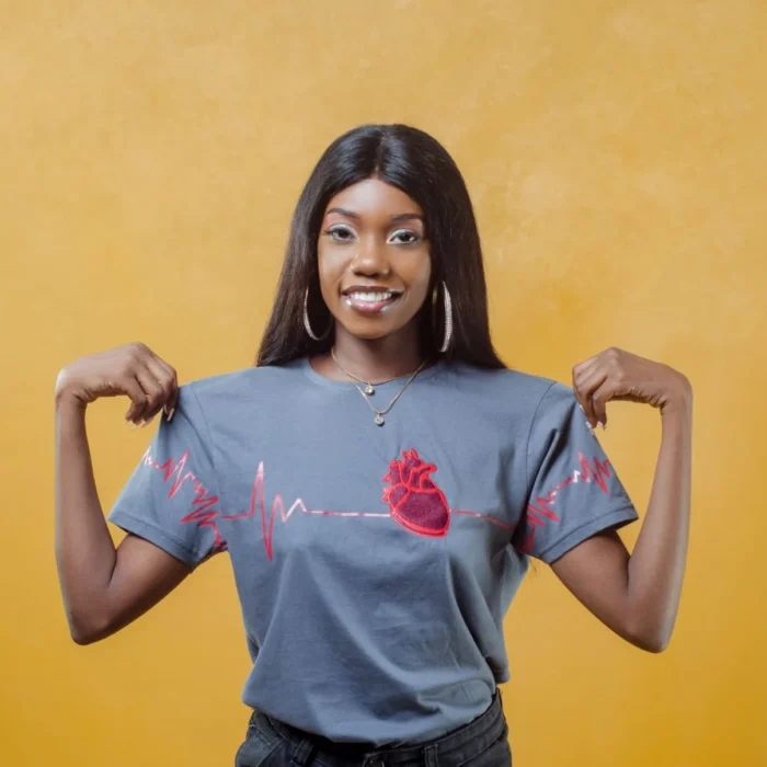 Modelo usando camiseta cinza Feel the Beat com coração anatômico e linha de ECG